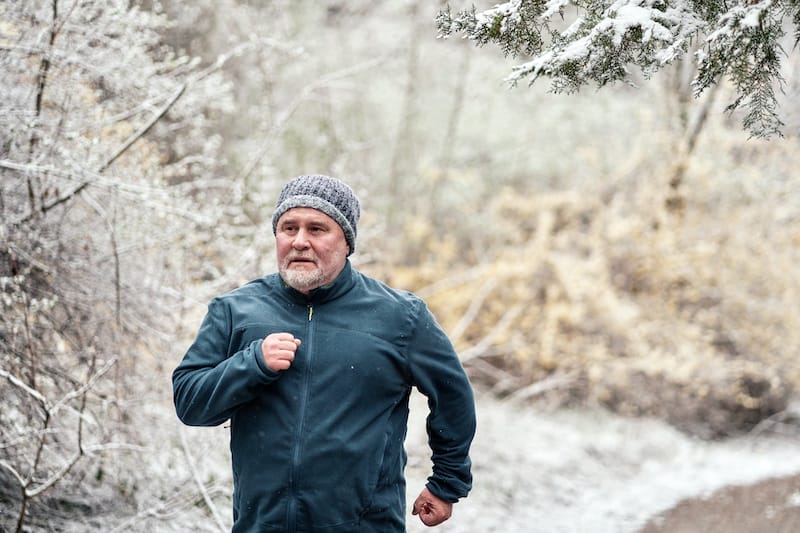Older man running outdoors in the winter cold
